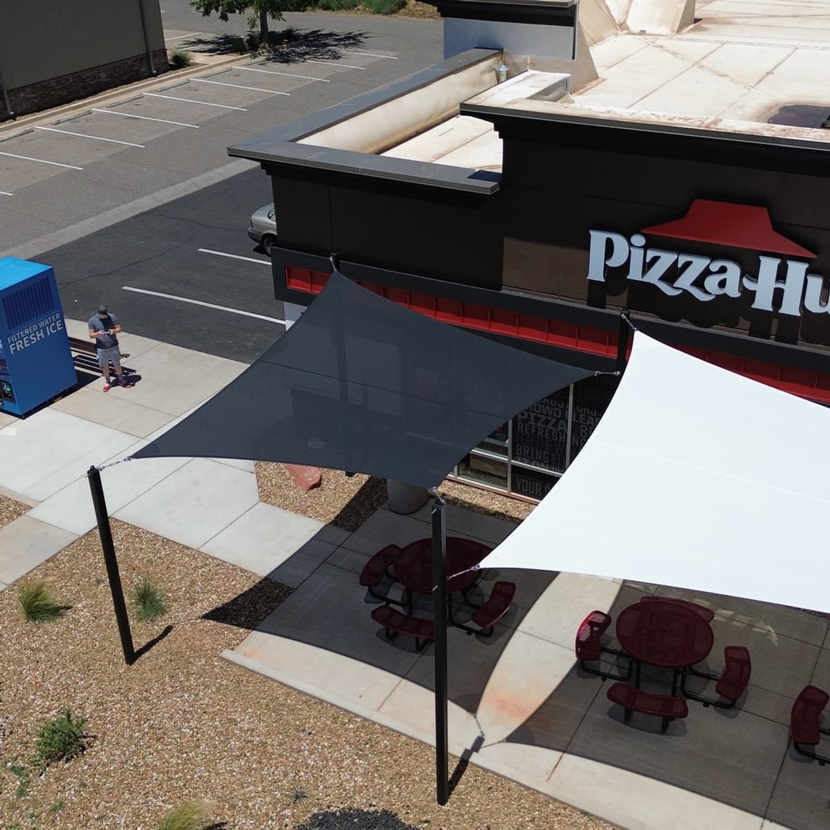 Commercial shade sails over a restaurant patio with outdoor seating