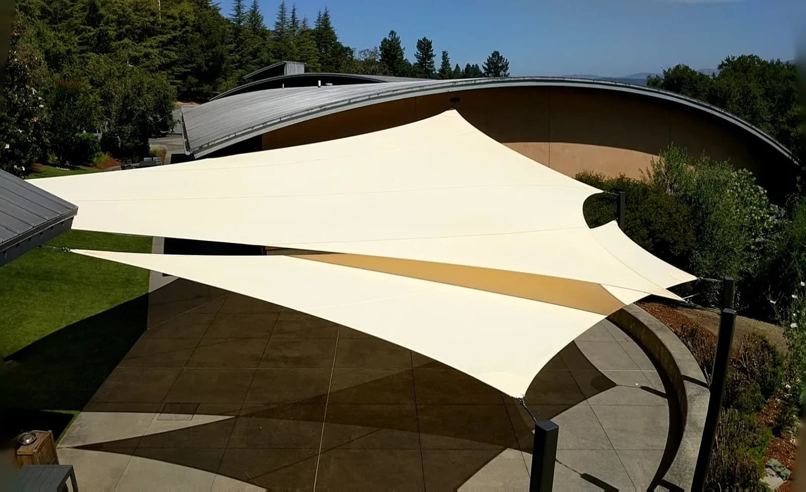 Tensioned shade sails over a finished outdoor space
